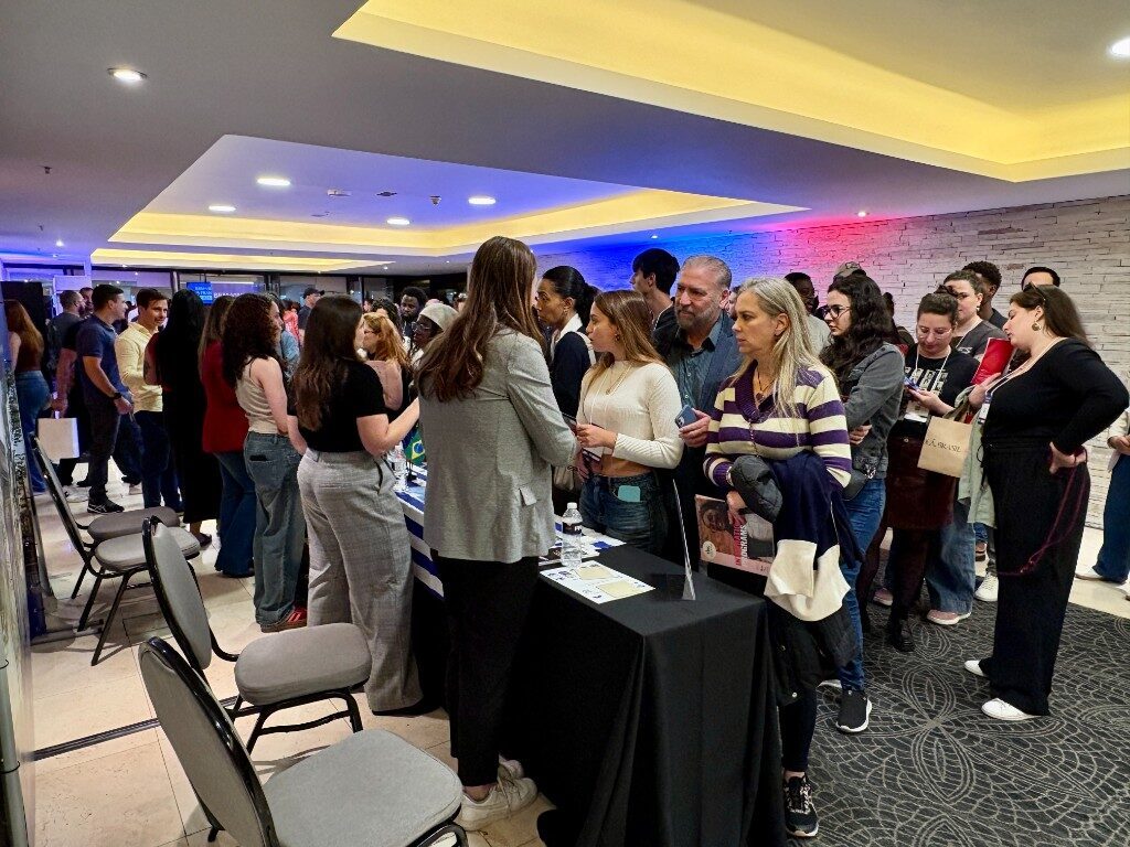Wide shot of the networking floor at The Student World EXPO Brazil — students engaging with multiple exhibitors